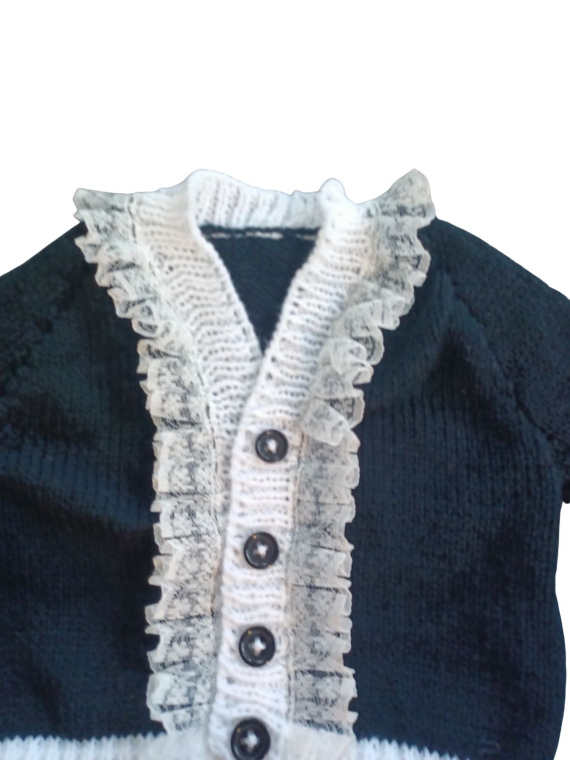 Long sleeved black cardigan with white trim and lace around the neck edge.