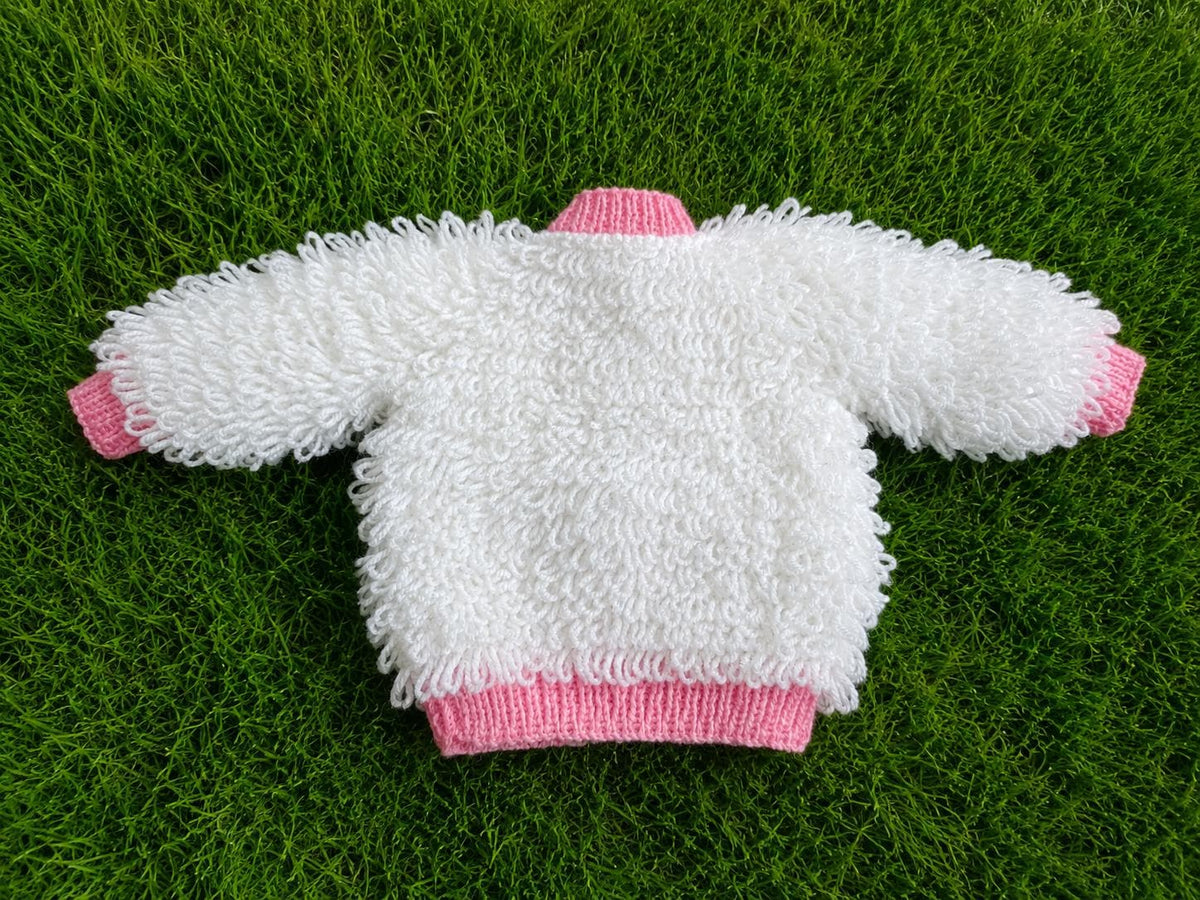 A white loopy-knit cardigan with pink edging, soft texture, and delicate pink buttons