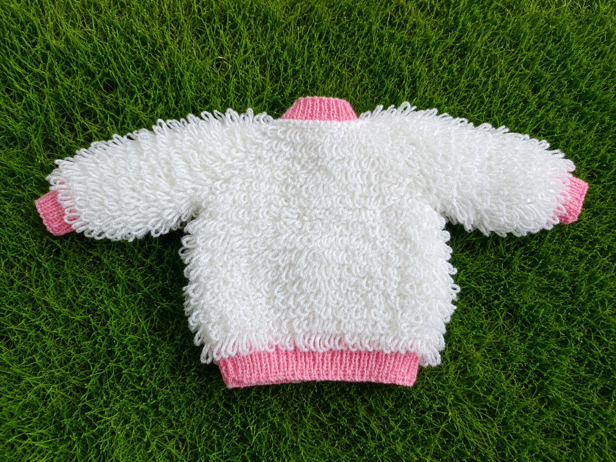 A lovely white loopy-knit cardigan with charming pink edging, soft texture, and delicate pink buttons for a beautifully feminine finish.