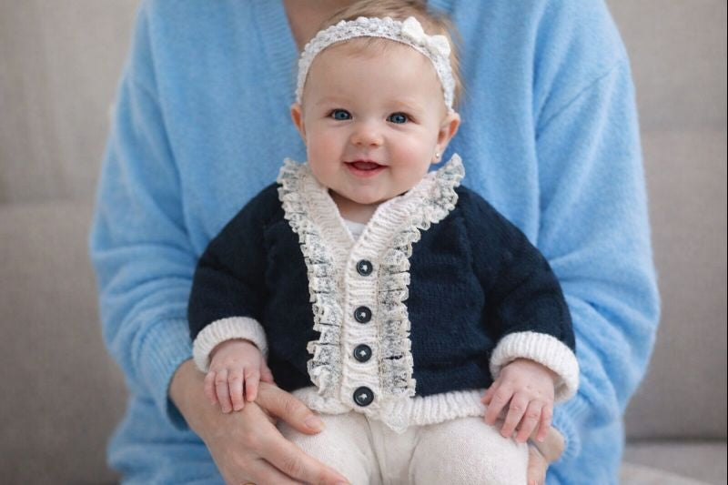 Black cardigan with white trim and lace edging.
