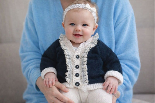 Black cardigan with white trim and lace edging.